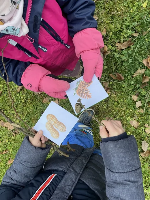 Kind entdeckt ein Spielkärtchen an einer Schnitzeljagd-Station